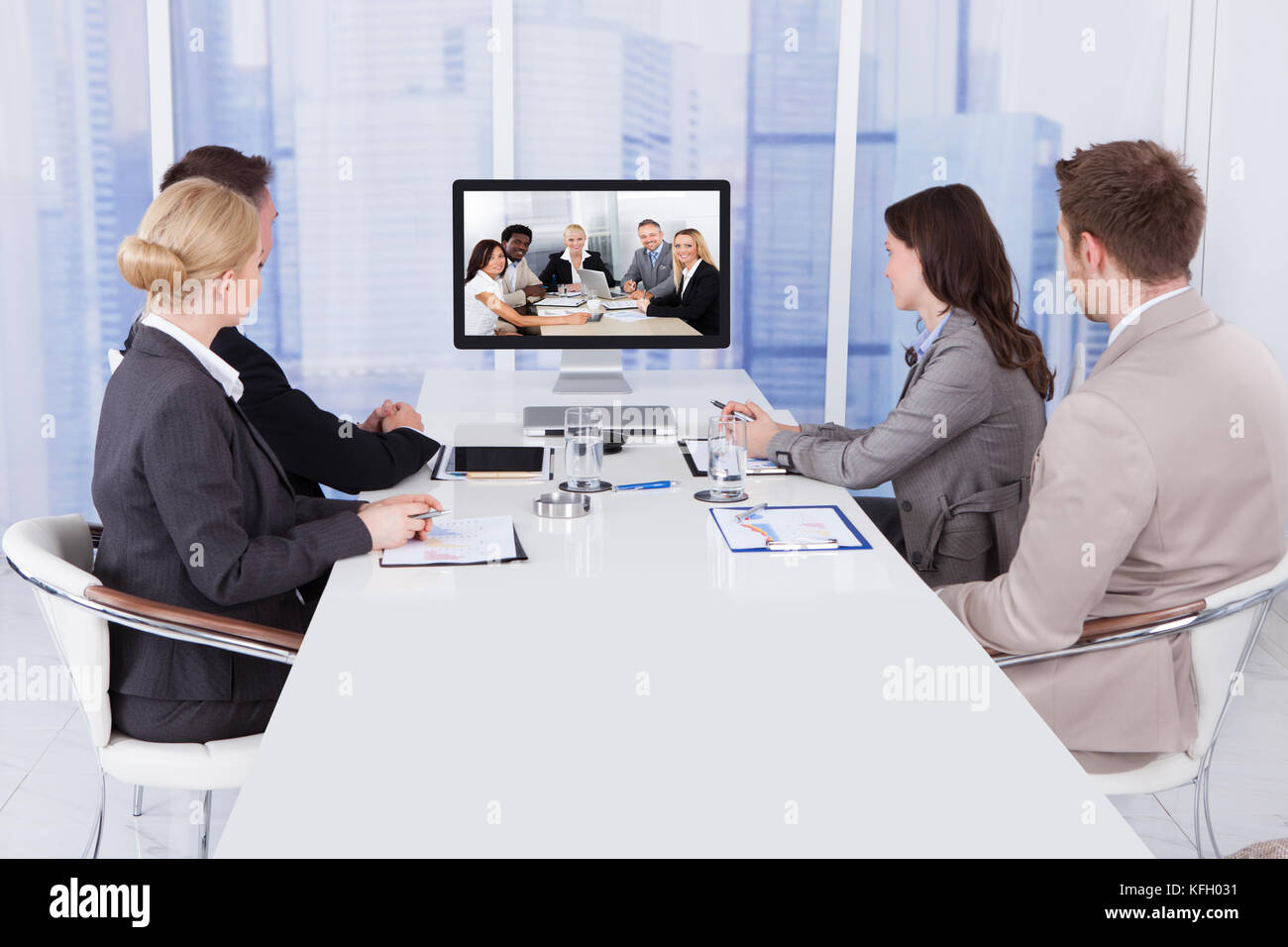 Gruppe von Geschäftsleuten in Video Konferenz am Konferenztisch Stockfoto