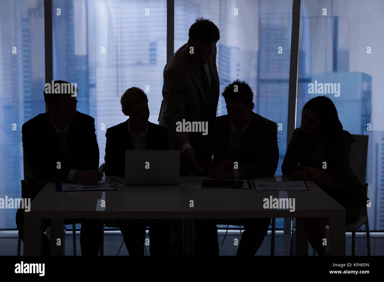 Silhouette der Unternehmer und Unternehmerinnen im Büro diskutieren Stockfoto