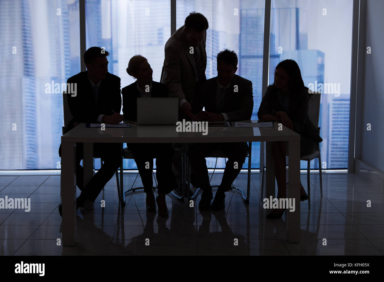 Silhouette der Unternehmer und Unternehmerinnen im Büro diskutieren Stockfoto