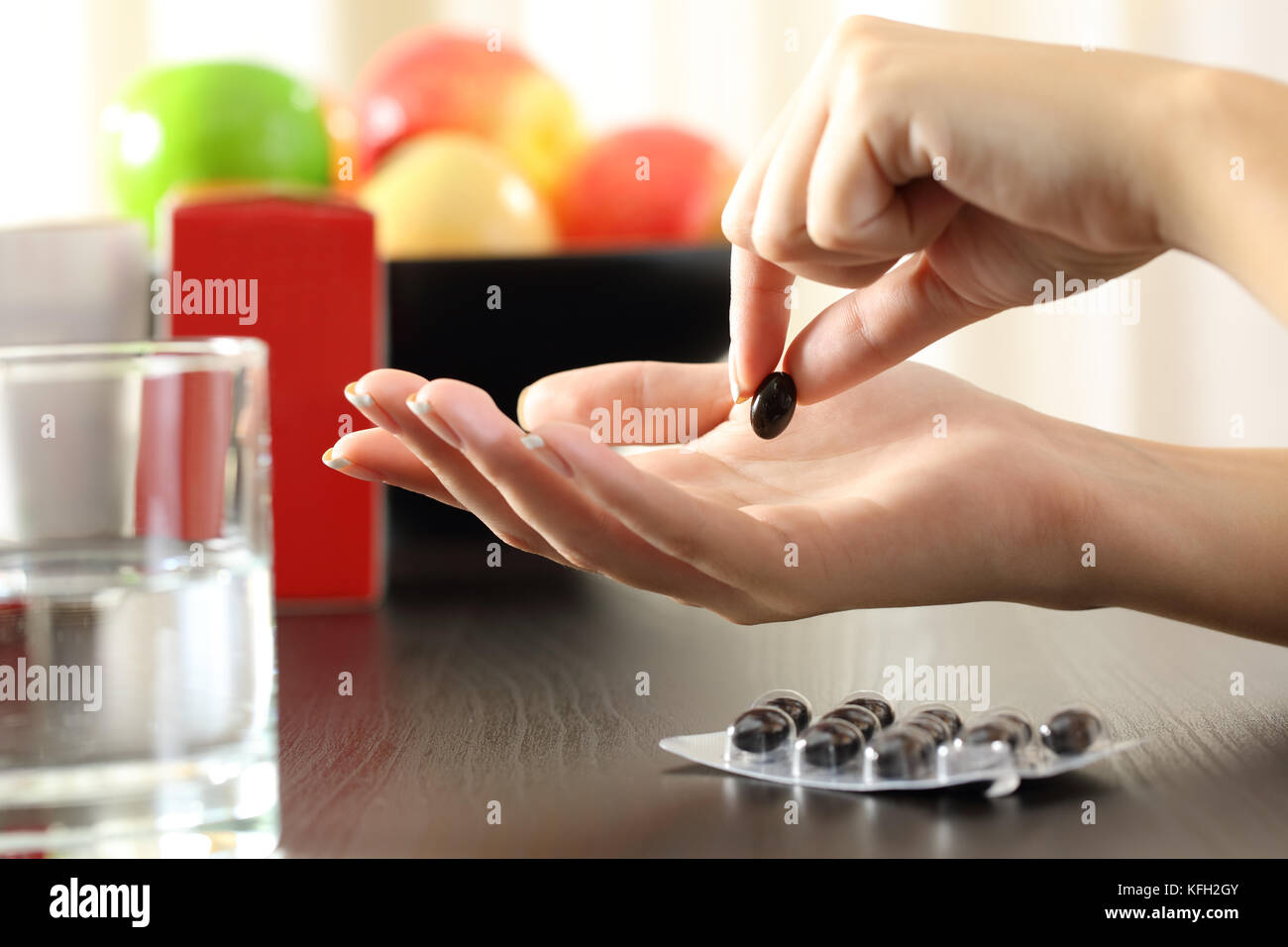Nahaufnahme einer Frau Hand fängt einen Vitamin Komplex Pille Stockfoto
