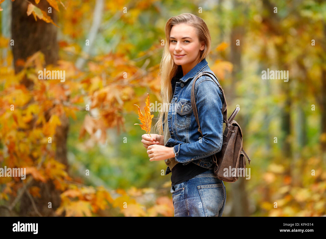 Hübsches blondes Mädchen mit schönen trockenen Maple Leaf in Hand in den Wald, genießen die Schönheit der Natur, fallen die Ausgaben Wochenende im Park Stockfoto