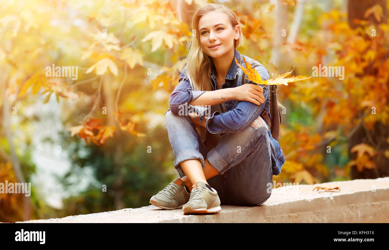 Nette weibliche in hellen, sonnigen Tag im Park sitzen und genießen schöne Herbst Natur und wundervolles Wetter, mit Vergnügen verbringen Wochenende outdoor Stockfoto