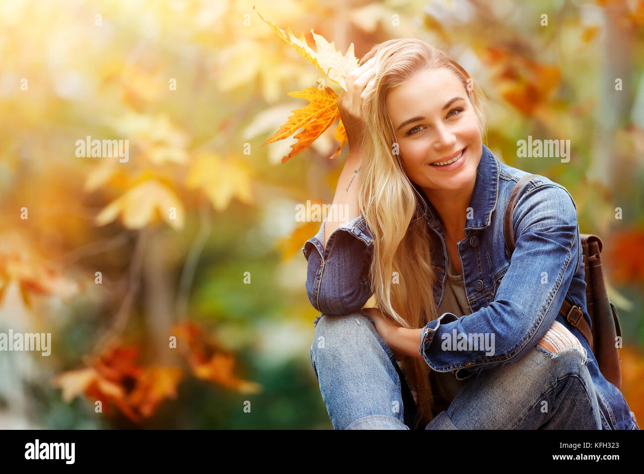 Glücklich lächelnde Frau im Herbst Wald sitzen, genießen letzten warmen sonnigen, herbstlichen Tagen, Ausgaben fallen Ferienhäuser im Park Stockfoto