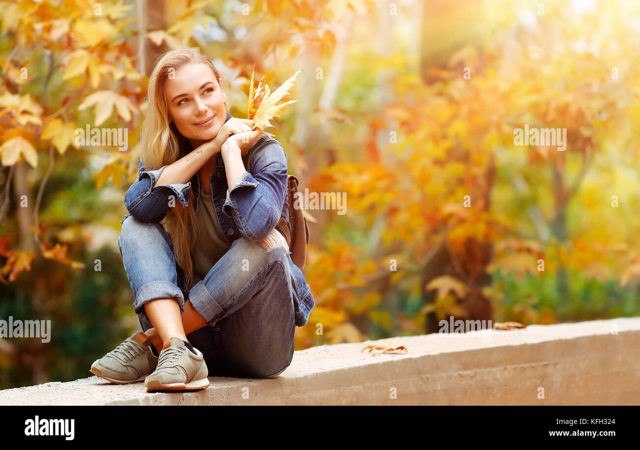 Nette weibliche in hellen, sonnigen Tag im Park sitzen und genießen schöne Herbst Natur und wundervolles Wetter, mit Vergnügen verbringen Wochenende outdoor Stockfoto
