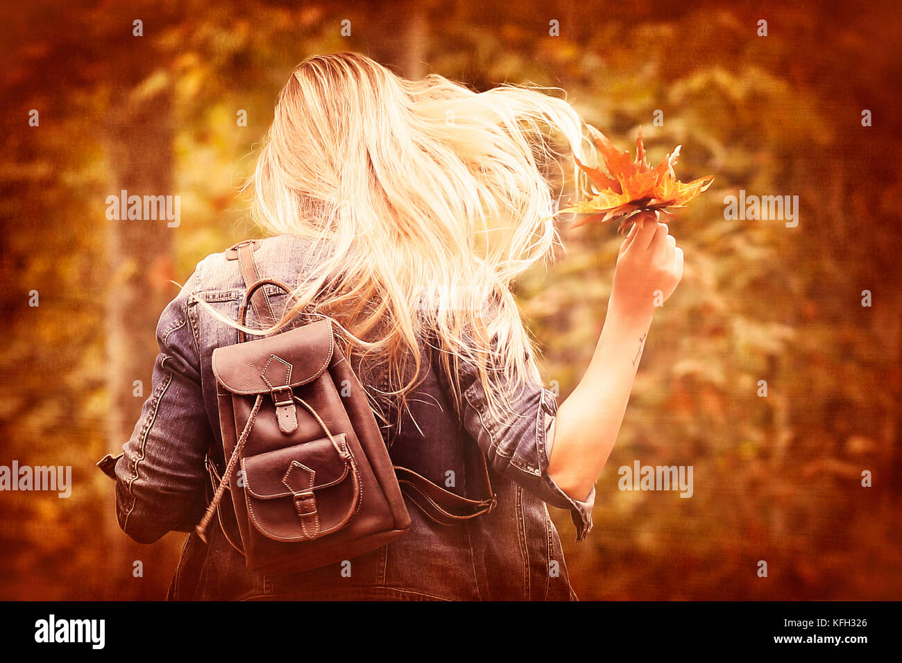 Vintage Style Foto von einer freudigen blondes Mädchen im Herbst Wald runing, Halten in der Hand trockenen Baum Blätter, Spaß im Herbst Park Stockfoto