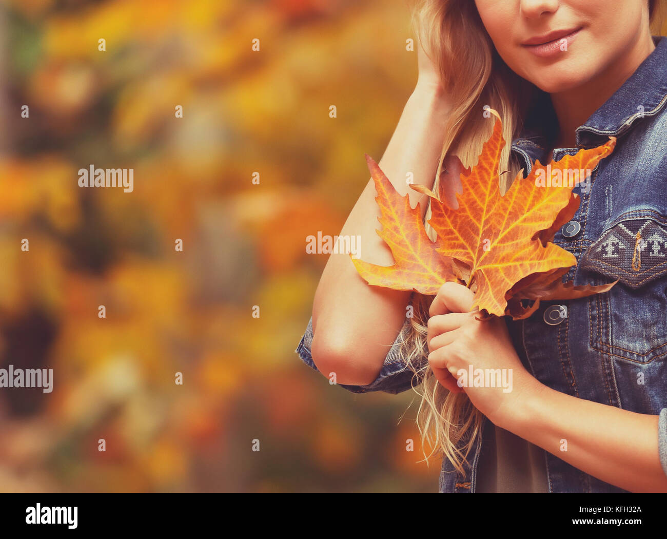 Nette weibliche über herbstliches Laub Hintergrund mit schönen trockenen Maple Leaf in der Hand, Herbstferien Konzept Stockfoto