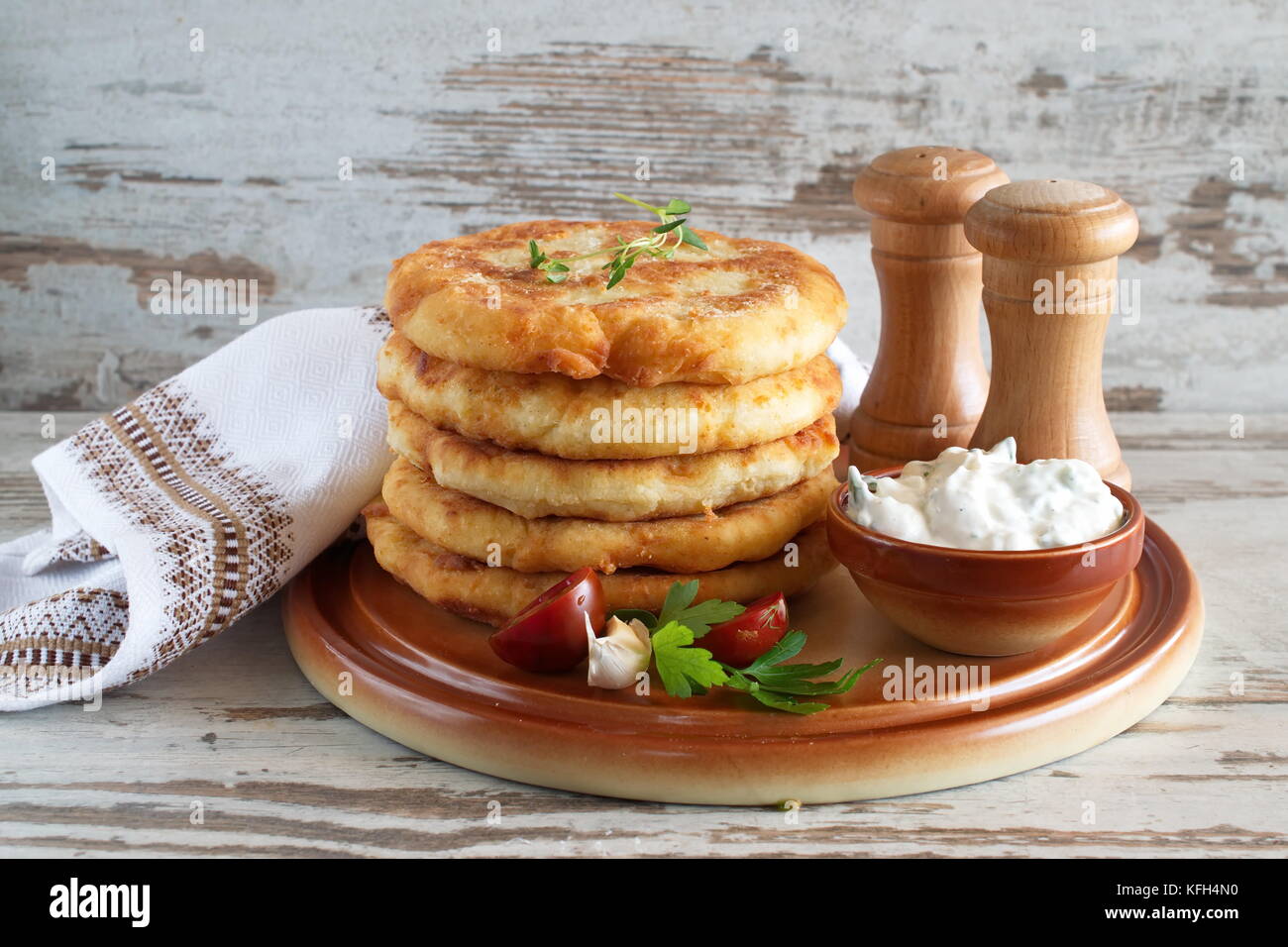 Gebratene Kartoffel Tortillas mit Joghurt Sauce und frischem Gemüse serviert. Stockfoto