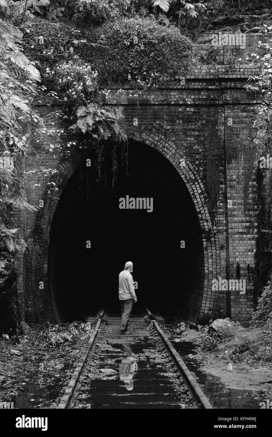 Einstehender Mann steht vor einem verlassenen Zugtunnel Stockfoto