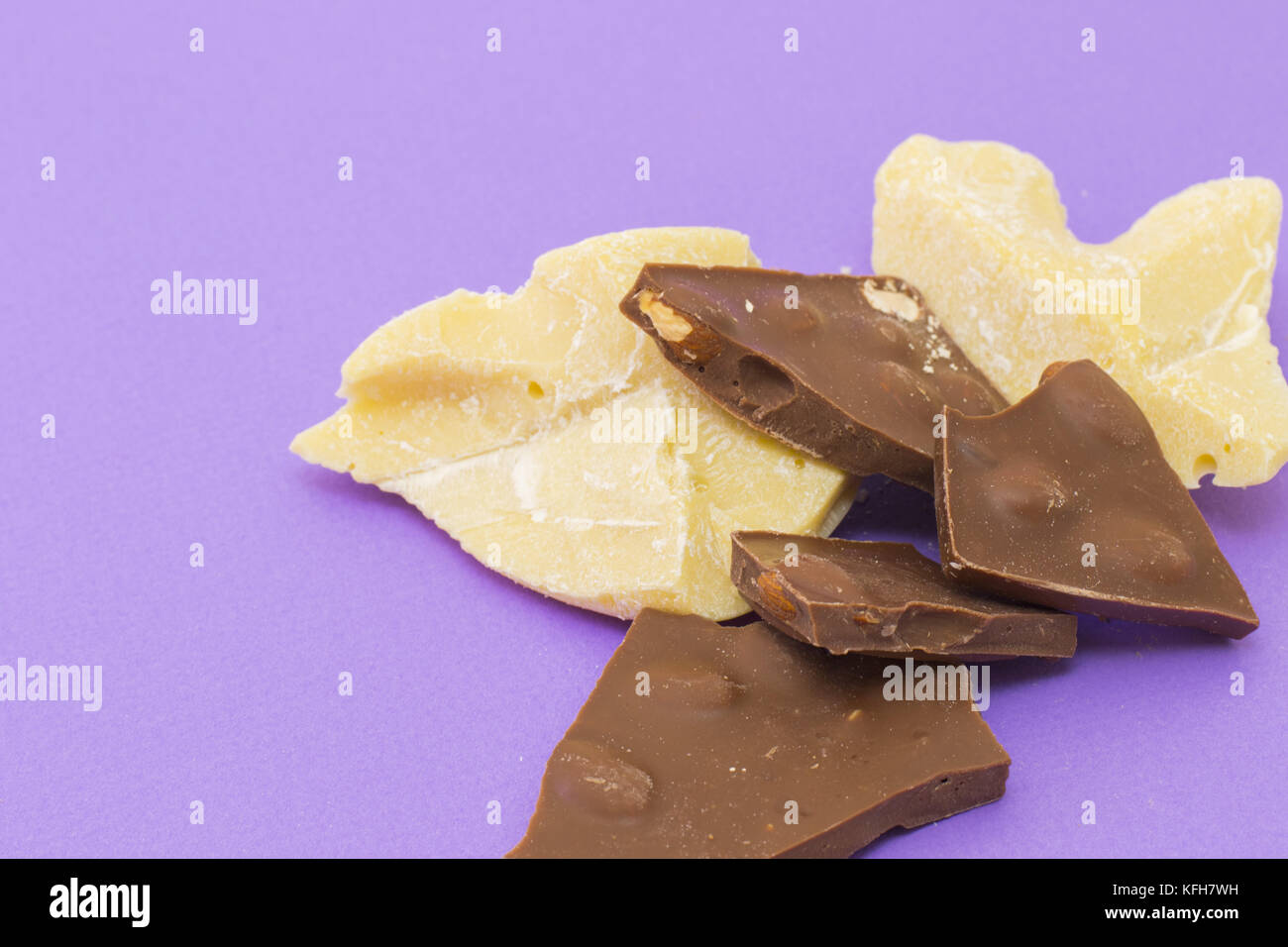 Milchschokolade mit Mandeln und Kakao Butter auf violette Hintergrund Stockfoto