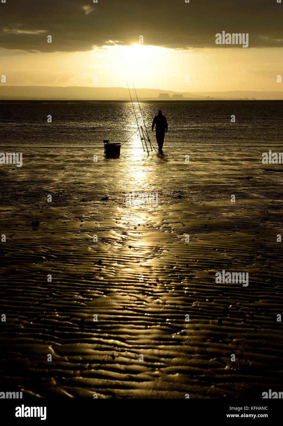Ein einstündiger Angler am Strand von Burnham-on-Sea, Somerset, da die Sonne eine Stunde früher untergeht, nachdem die Uhren letzte Nacht eine Stunde zurückgegangen sind, aufgrund des Endes der Sommerzeit und des Umschalters von der britischen Sommerzeit (BST) zur Greenwich Mean Time (GMT). Stockfoto