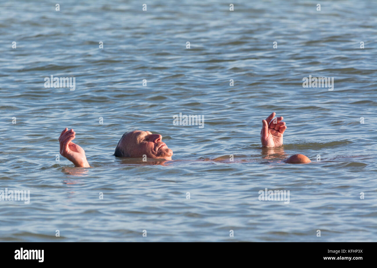 Ein Mann mittleren Alters entspannen im Meer an heißen, sonnigen Tag. Stockfoto