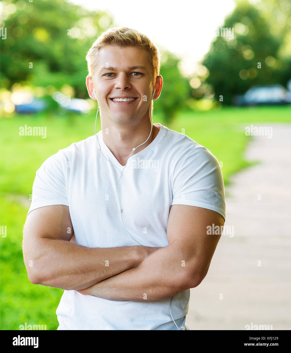 Jungen athletischen Mann glücklich lächelnd. Trainer Mann und starker Kerl portrait. In der Natur im Park im Sommer. Kraft und Motivation Stockfoto