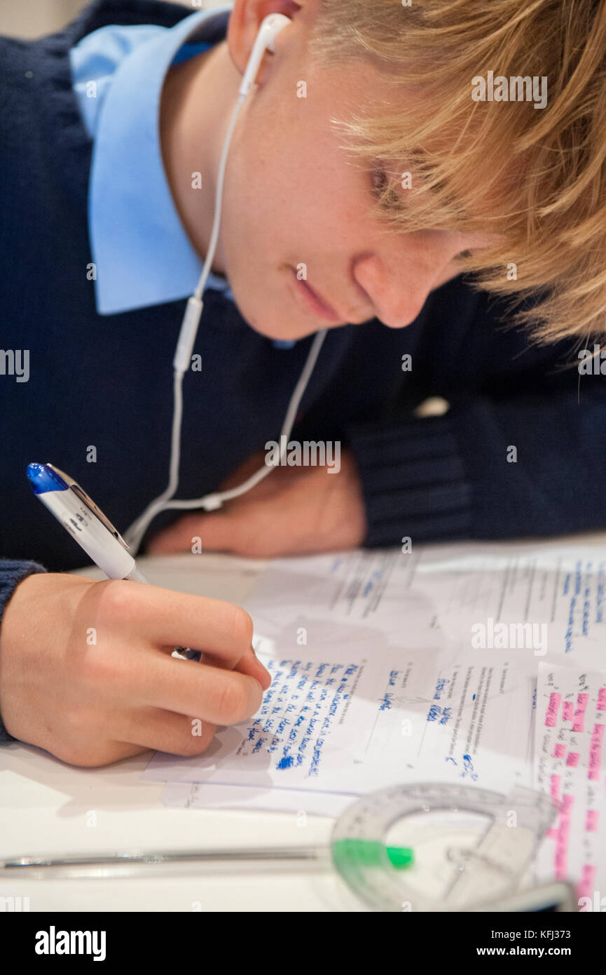 Ein kleiner Junge hat seine Hausaufgaben am Küchentisch in Vorbereitung auf die kommenden Prüfungen Stockfoto