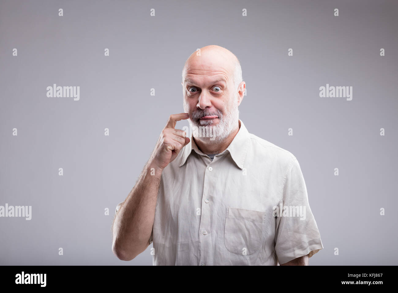 Alter Mann mit Glatze eine Geste, dass bedeutet, dass ffood köstlich ist und er will es jetzt zu essen Stockfoto