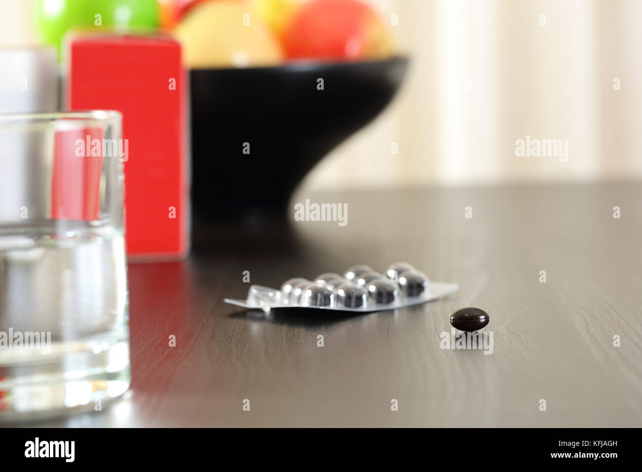 Nahaufnahme eines Vitamin Komplex Pillen auf einem Tisch mit Früchten im Hintergrund Stockfoto