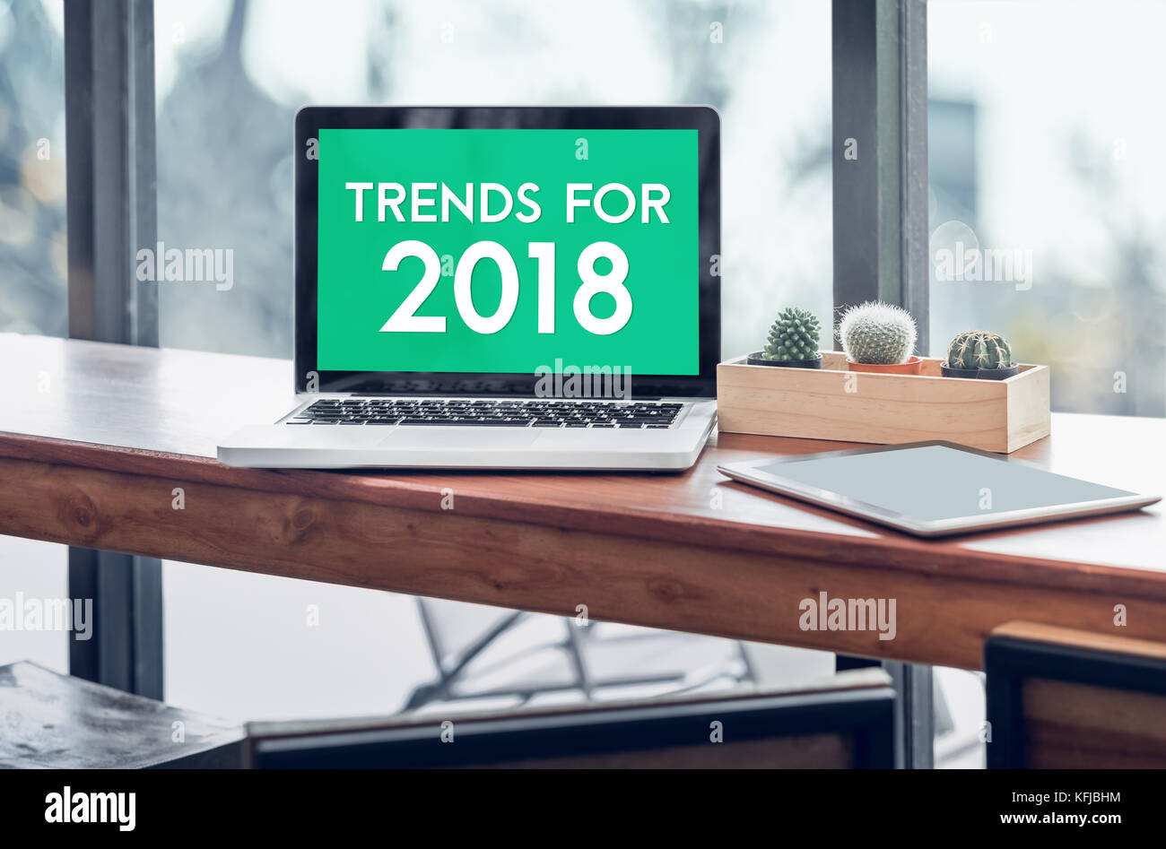 Trends für 2018 Wort in Laptop mit Tablet auf Holz stand Tabelle im Fenster mit unscharfen Hintergrund, digitale Wirtschaft oder Marketing trendin Stockfoto