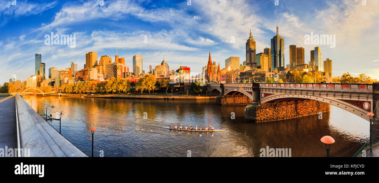 Warme goldene Licht über die Stadt Melbourne CBD über den Fluss Yarra von southbank zwischen Fuß foot bridge und Fürsten Brücke in früher Morgen. Stockfoto