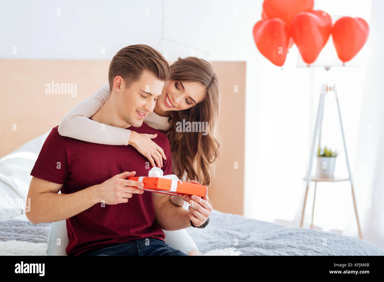 Liebevolle Mädchen gratulieren ihrem Freund zu Hause Stockfoto