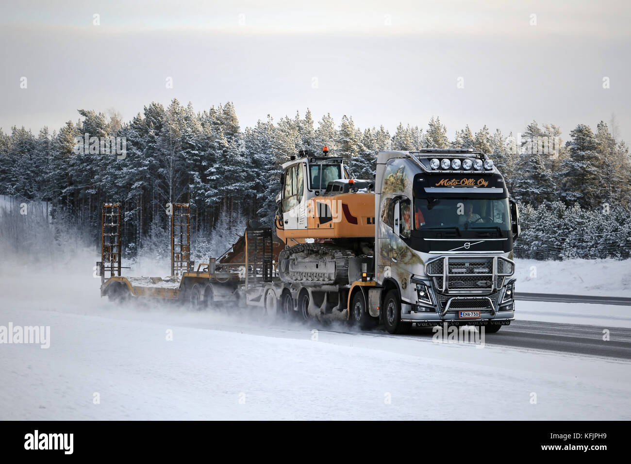 PAIMIO, FINNLAND - 17. JANUAR 2016: Der Volvo FH16 750 mit Gemälden und Bullenbalken von Moto-Olli Oy bringt Liebherr R 918 Raupenbagger auf Mo Stockfoto