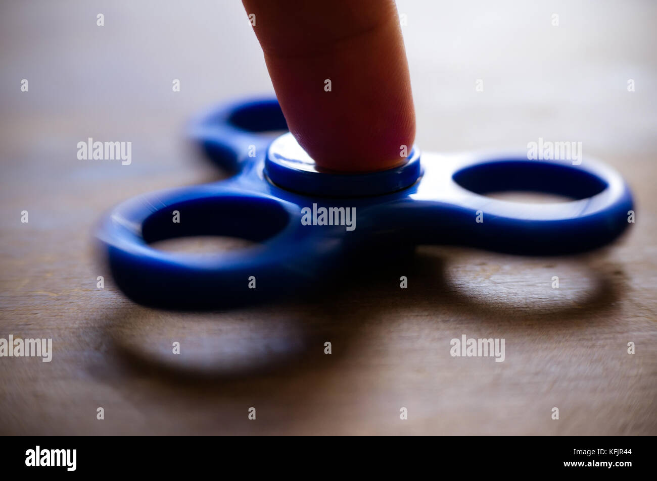 Leistungsstarke Spinner, Twister für Hände Unterhaltung rotierende Spielzeug. die Hände des Kindes Spinner auf einem Holztisch twist Stockfoto