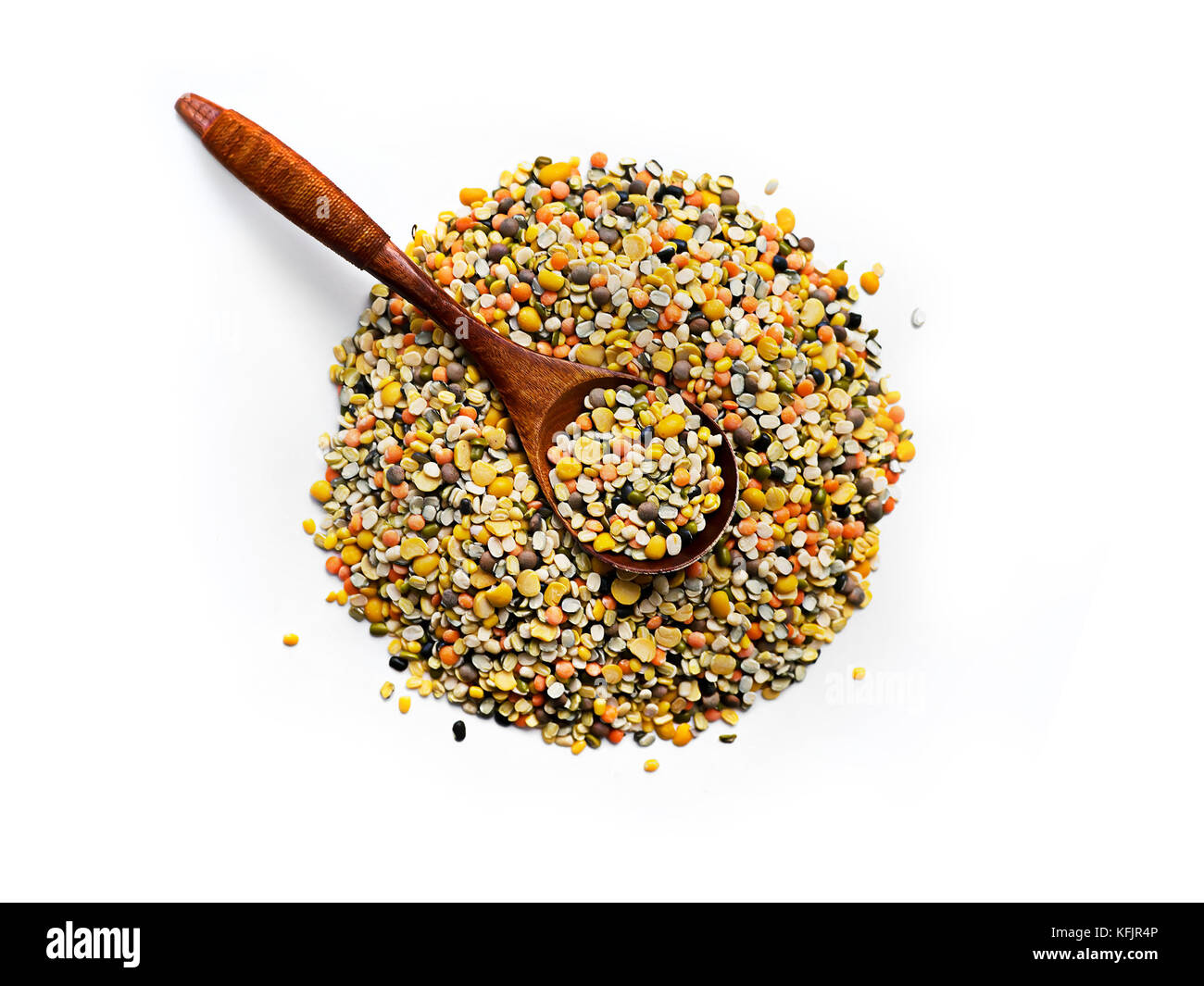 Gemischte Hülsenfrüchte in einem Kochlöffel auf weißem Hintergrund. Gemischte Linsen in einem kleinen Stapel Stockfoto