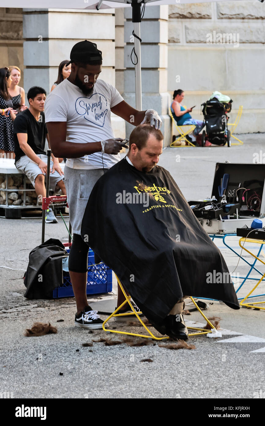 African American Barber schneidet im Innenhof des City Hall, Philadelphia, Pennsylvania, USA, für freie weiße Arme Stockfoto