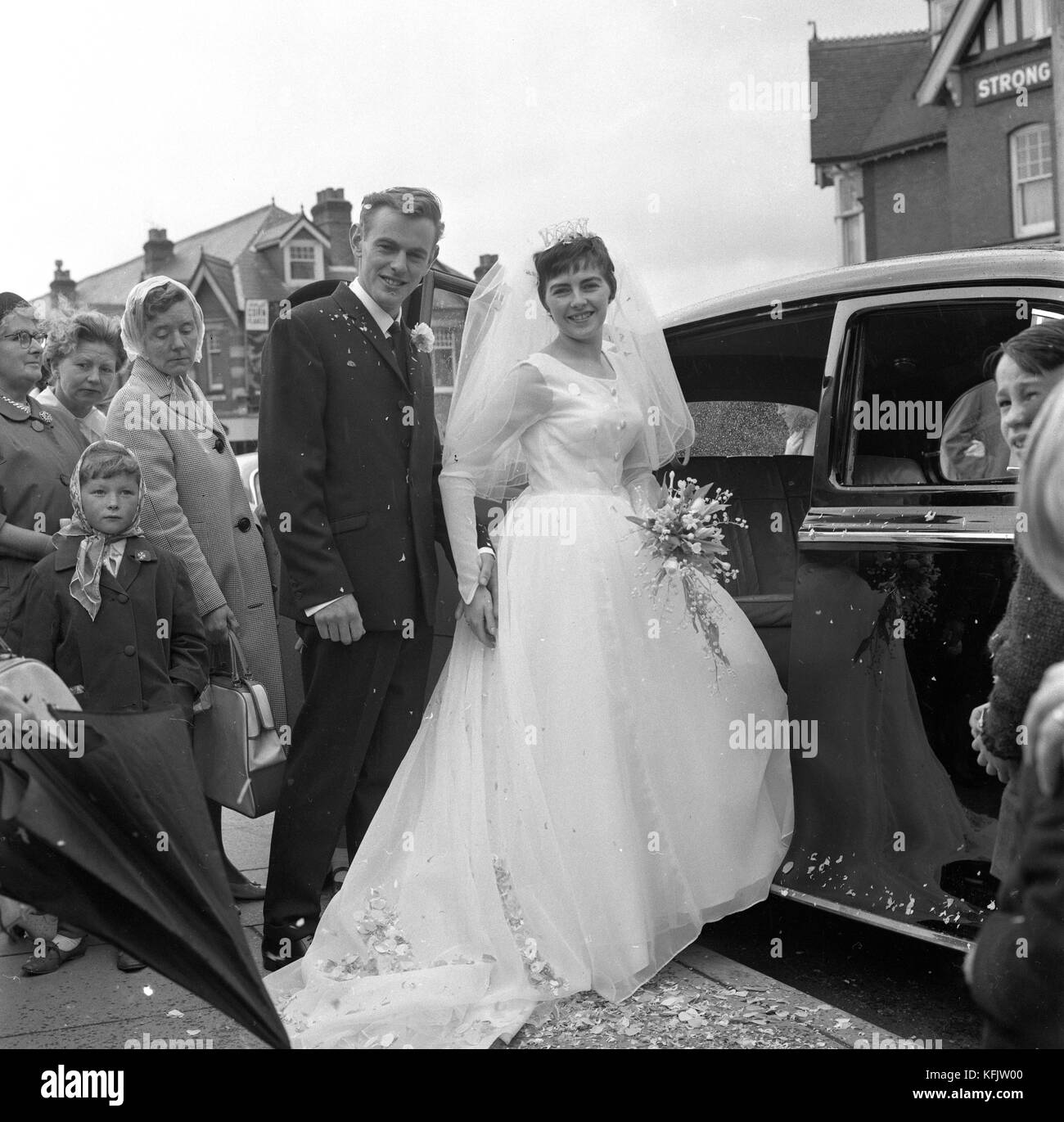 Die Kirche verlassen wie ein Ehepaar. Die Hochzeit von Herrn und Frau Morgan an der Pfarrkirche des Hl. Johannes des Evangelisten in parkstone, Poole, Dorset. c 1965. Foto von Tony henshaw Stockfoto