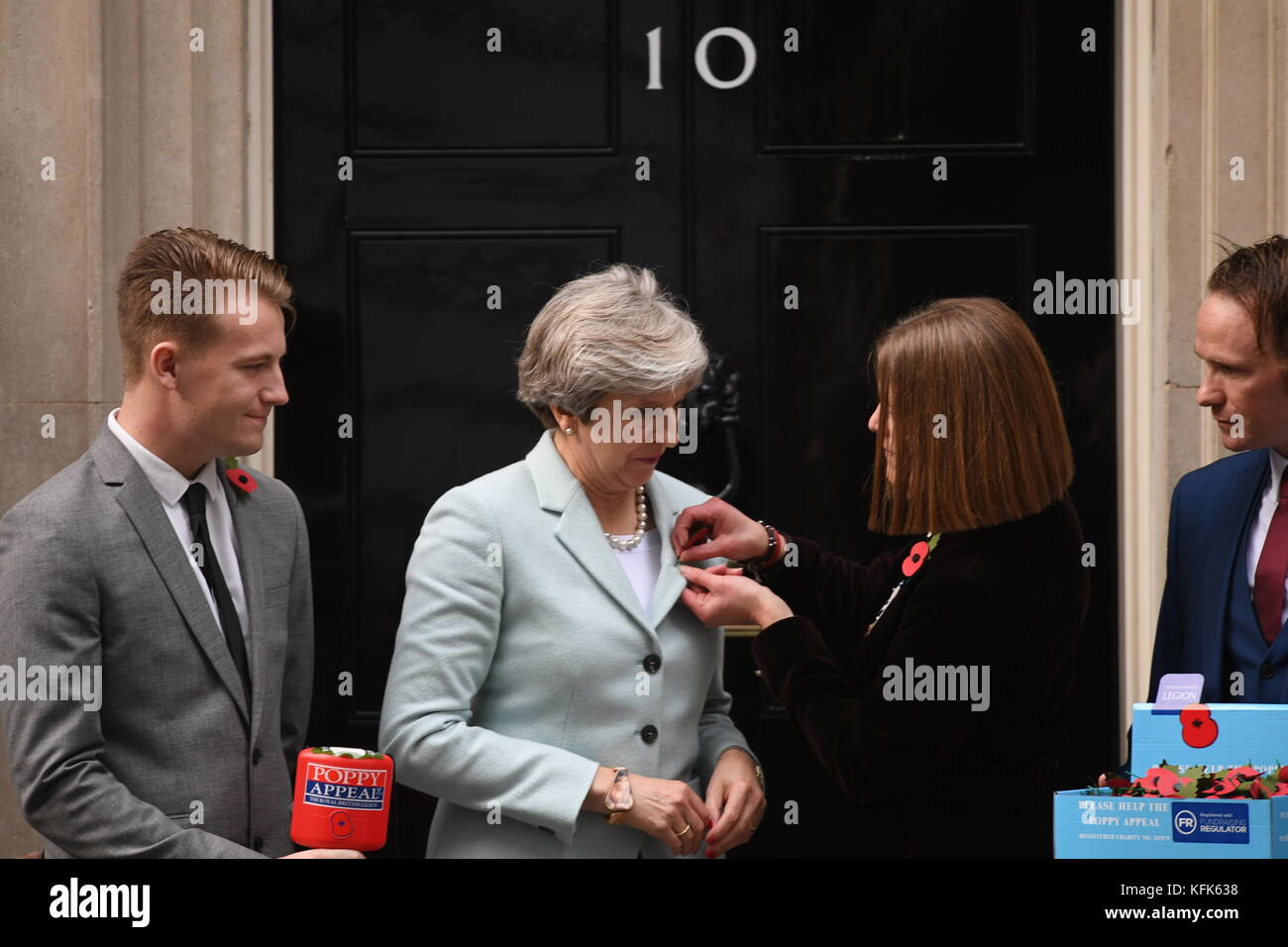 Premierministerin Theresa May spendet dem Poppy Appeal der Royal British Legion und empfängt ihren Mohn, als sie vor der Downing Street 10 in London die Leiterin der Spendenaktion der Wohltätigkeitsorganisation Claire Rowcliffe und die Spendensammler George Taylor (links) und Paul Wheeler trifft. Stockfoto