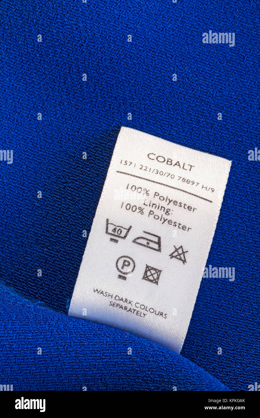 100% Polyester Futter 100% Polyester Label in der Frau kobalt Jacke mit Sorgfalt Waschanleitung Symbole - dunkle Farben separat waschen Stockfoto