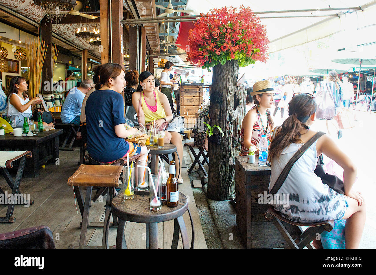 Touristen genießen einen Drink in einem angesagten Café in Bangkoks berühmtes Chatuchak Weekend Market, Thailand, South East Asia. Stockfoto