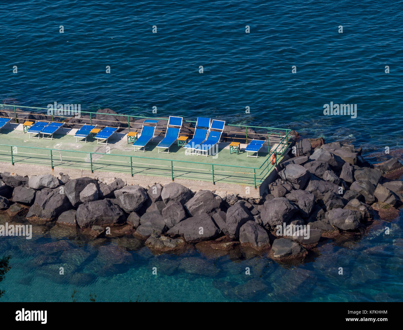 Leere Liegestühle auf der Sonnenterrasse vom Mittelmeer umgeben. Sorrento, Italien. Stockfoto