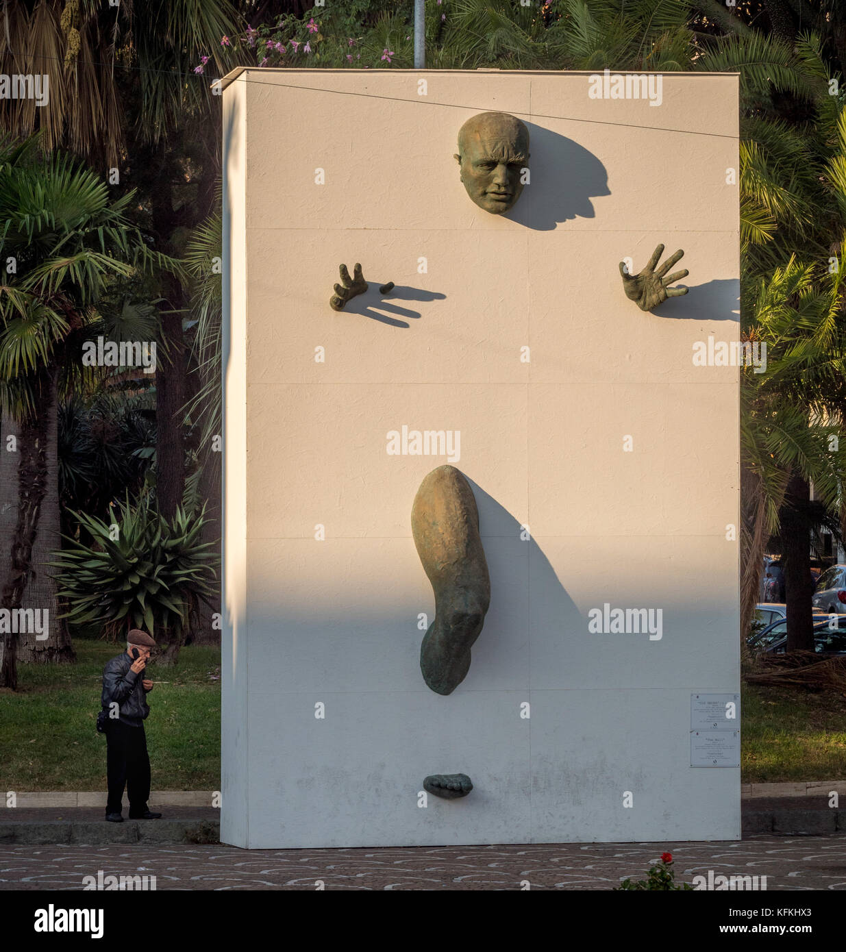 Männliche Skulptur aus Bronze, die sich aus einer weißen Wand. Die Wand, eine Ausstellung von der Wirbel Ausstellung von Matteo Pugliese. Sorrento. Italien. Stockfoto
