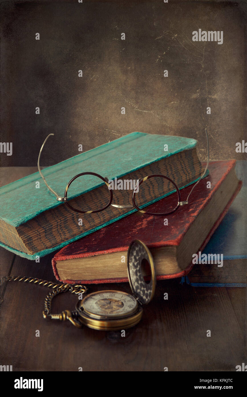 Alte Vintage Books mit Taschenuhr und Brillen Stockfoto
