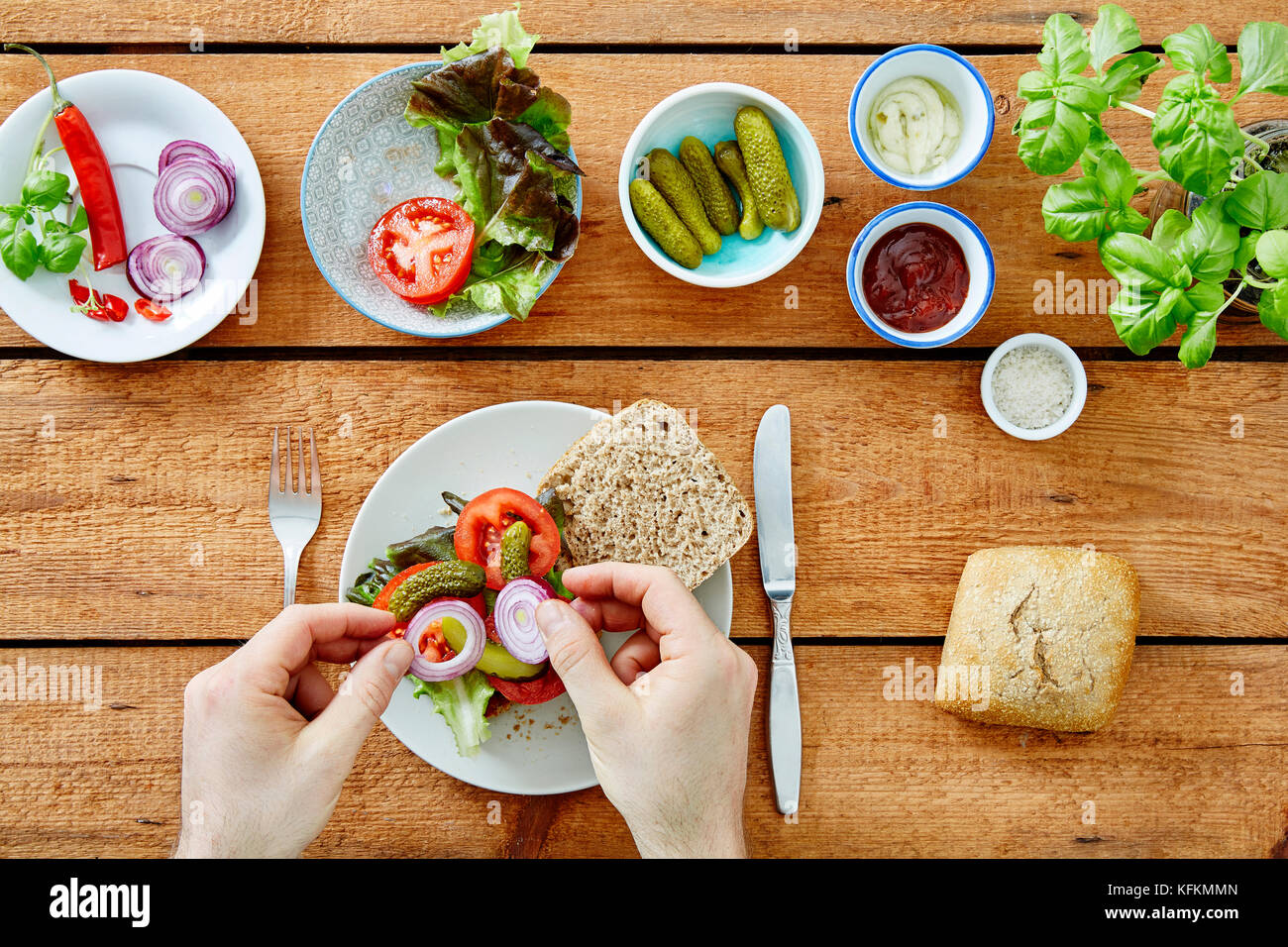 Hand Zutaten hinzufügen zu einem frischen organischen Sandwich Stockfoto