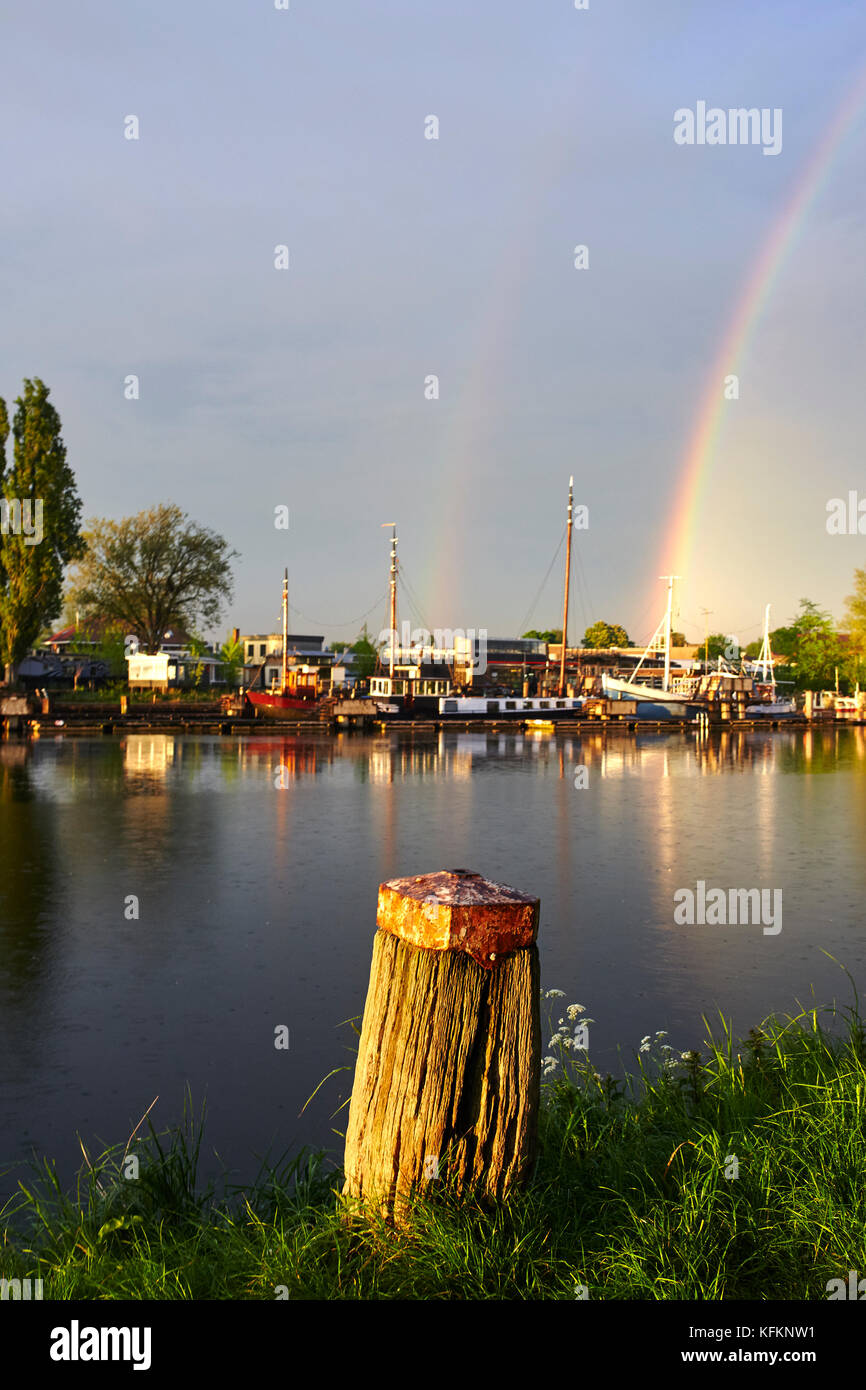 Poller mit Regenbogen auf Kanal in Amsterdam, Niederlande Stockfoto