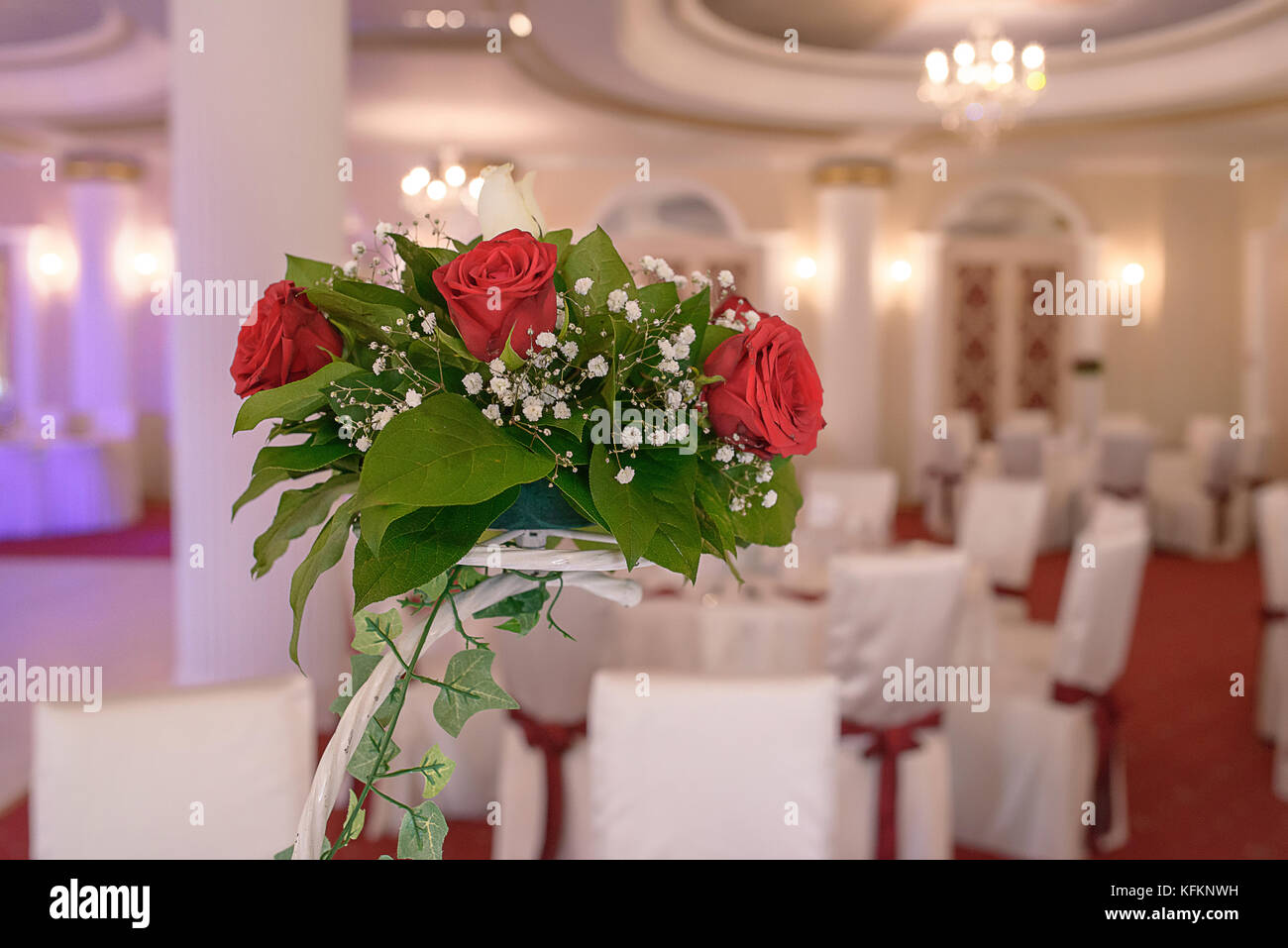 Rote Rosen Herzstück bei einer Hochzeit. Dekorative Darstellung eines Blumenschmuck in einem großen Veranstaltungsort Stockfoto