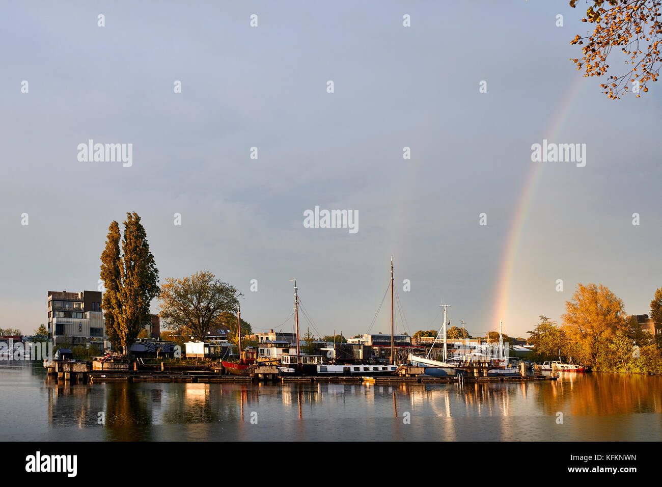 Sonnenuntergang und Regenbogen über Kanäle in Amsterdam Niederlande Stockfoto