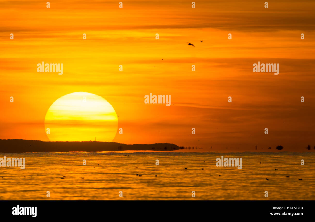 Sonnenuntergang über dem Meer mit rot und orange sky im Herbst in Großbritannien. Stockfoto