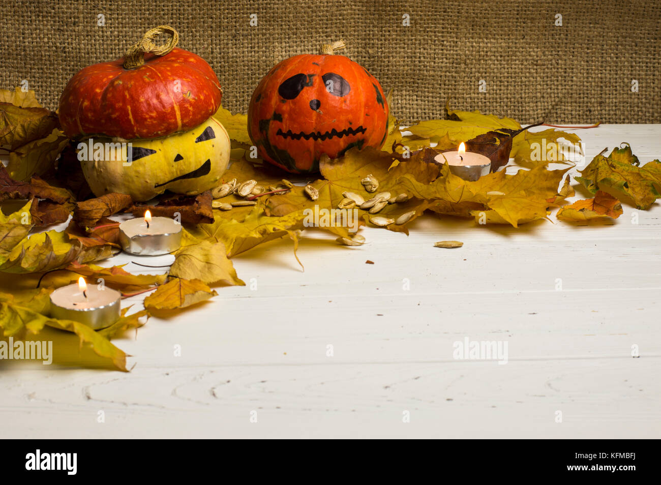 Halloween Kürbisse und Kerzen unter Blätter im Herbst Stockfoto