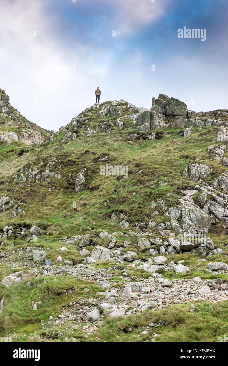 Cot Valley Cornwall - ein einsamer Mann, der auf einem Felsvorsprung mit Blick auf Cot Valley in Cornwall steht. Stockfoto