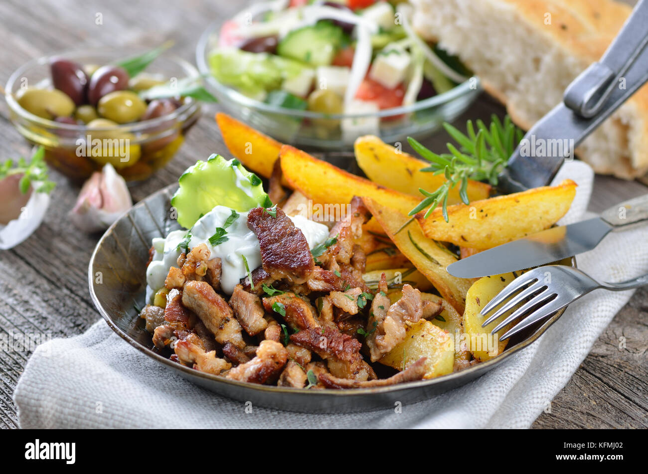 Griechische Schwein Gyros in eine eiserne Pfanne, serviert mit ...