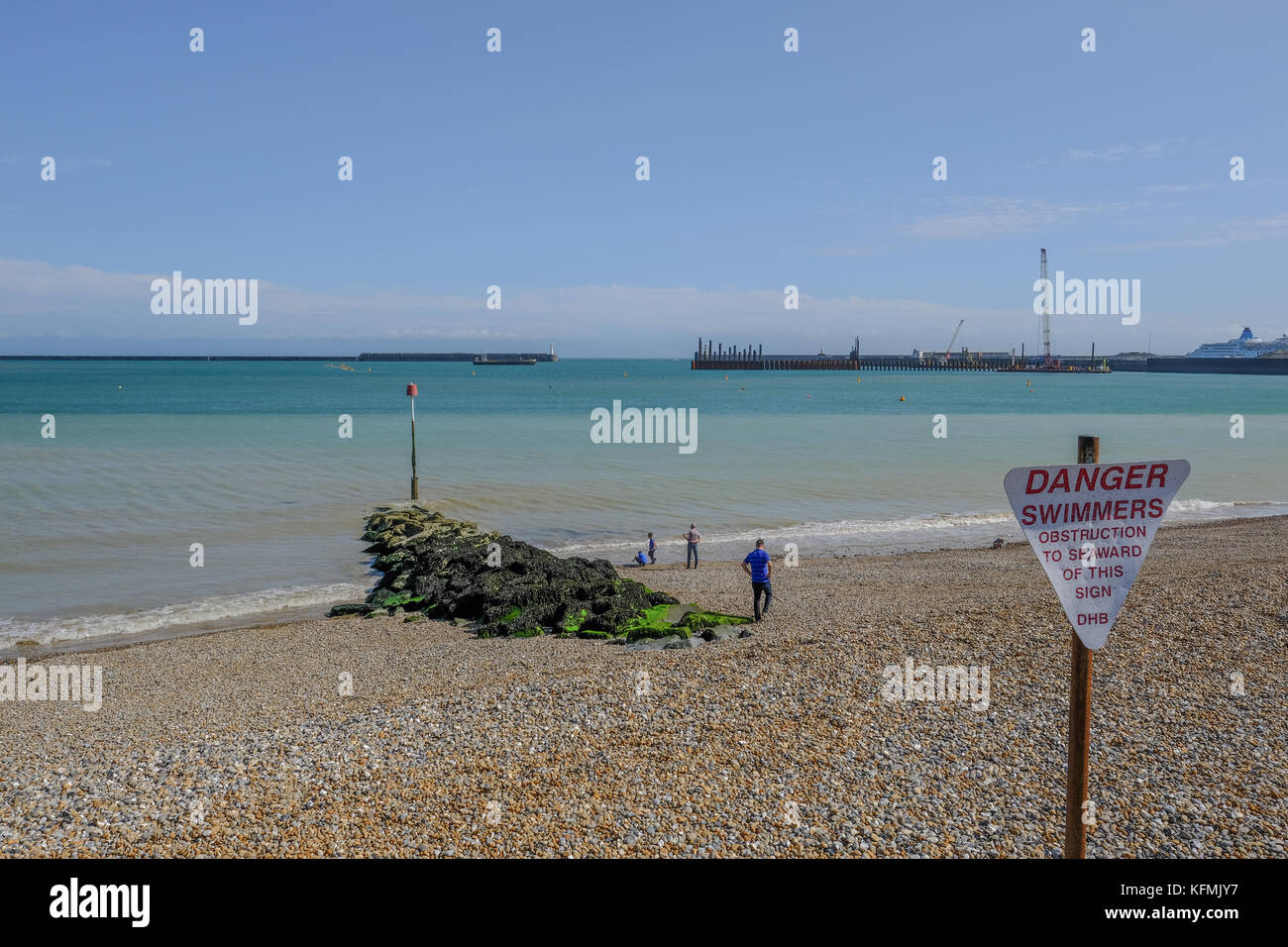 Dover, Kent, Großbritannien - 17. August 2017: Strand in Dover im Hafen mit groyne. zeigt Menschen genießen Sie den sonnigen Tag am Strand. Stockfoto
