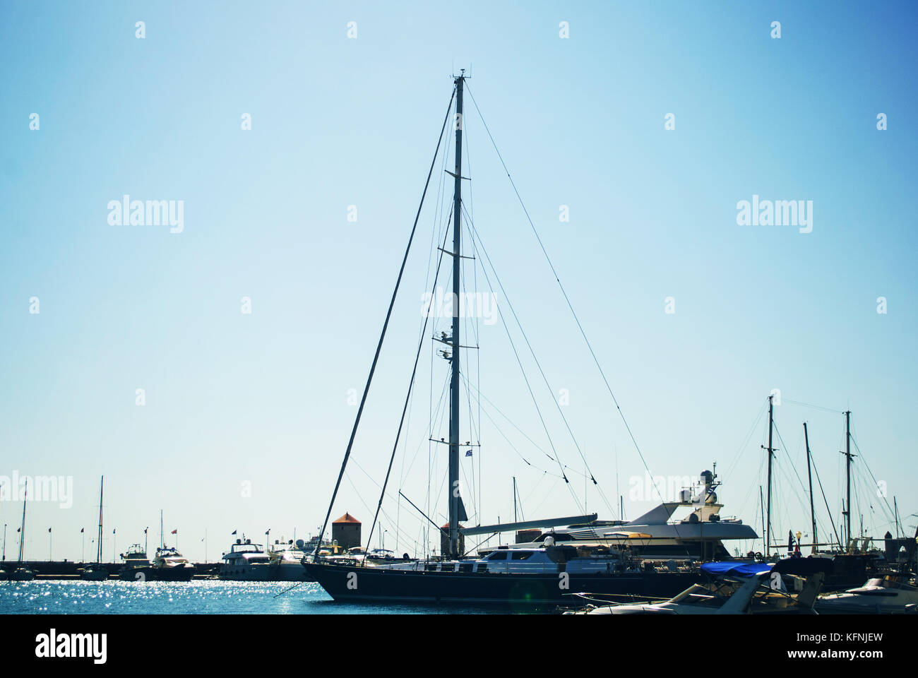 Mandrake Hafen, Insel Rhodos, Griechenland. Schiff mit Segel hoch, Aufruf am Hafen. Ist dies eine außergewöhnlich sonnigen Tag war, dem Gegensatz zwischen Licht und d Stockfoto