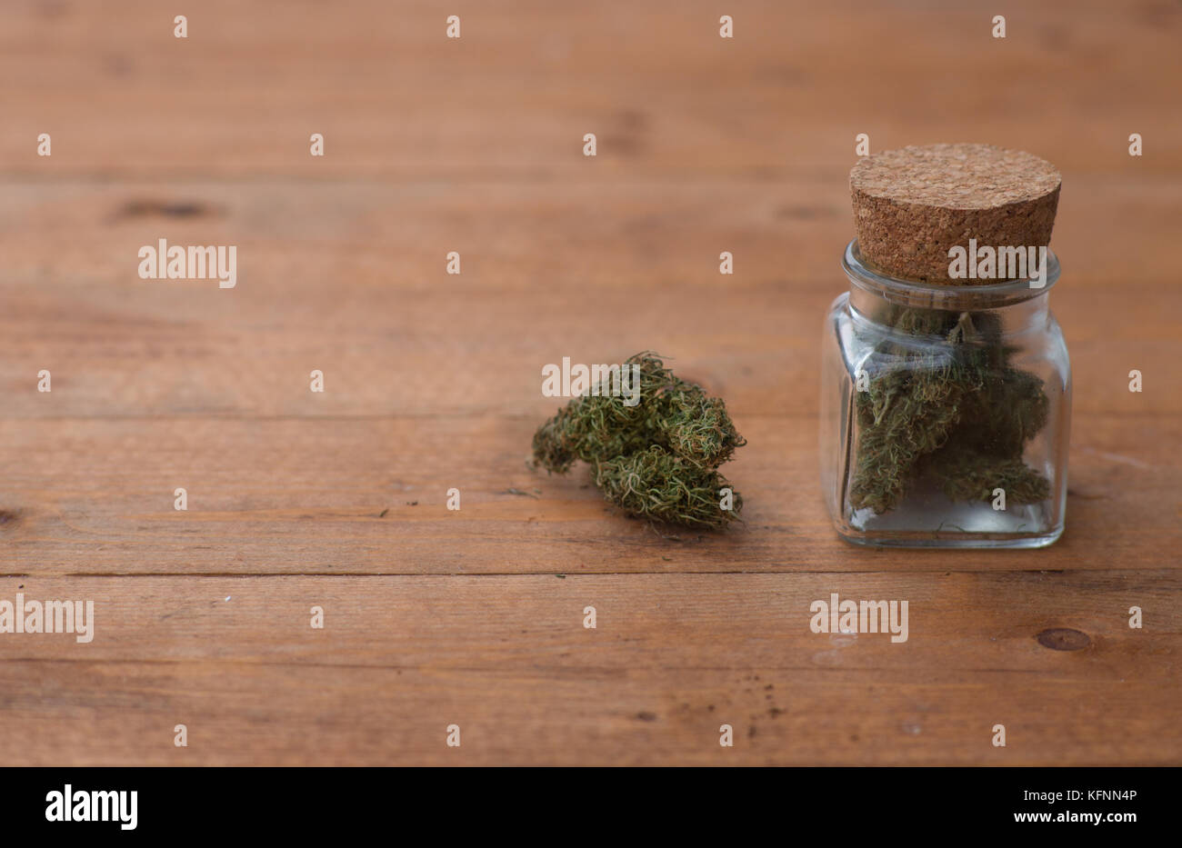 Ein Glas mit medizinischen Marihuana auf einem Holztisch. Stockfoto