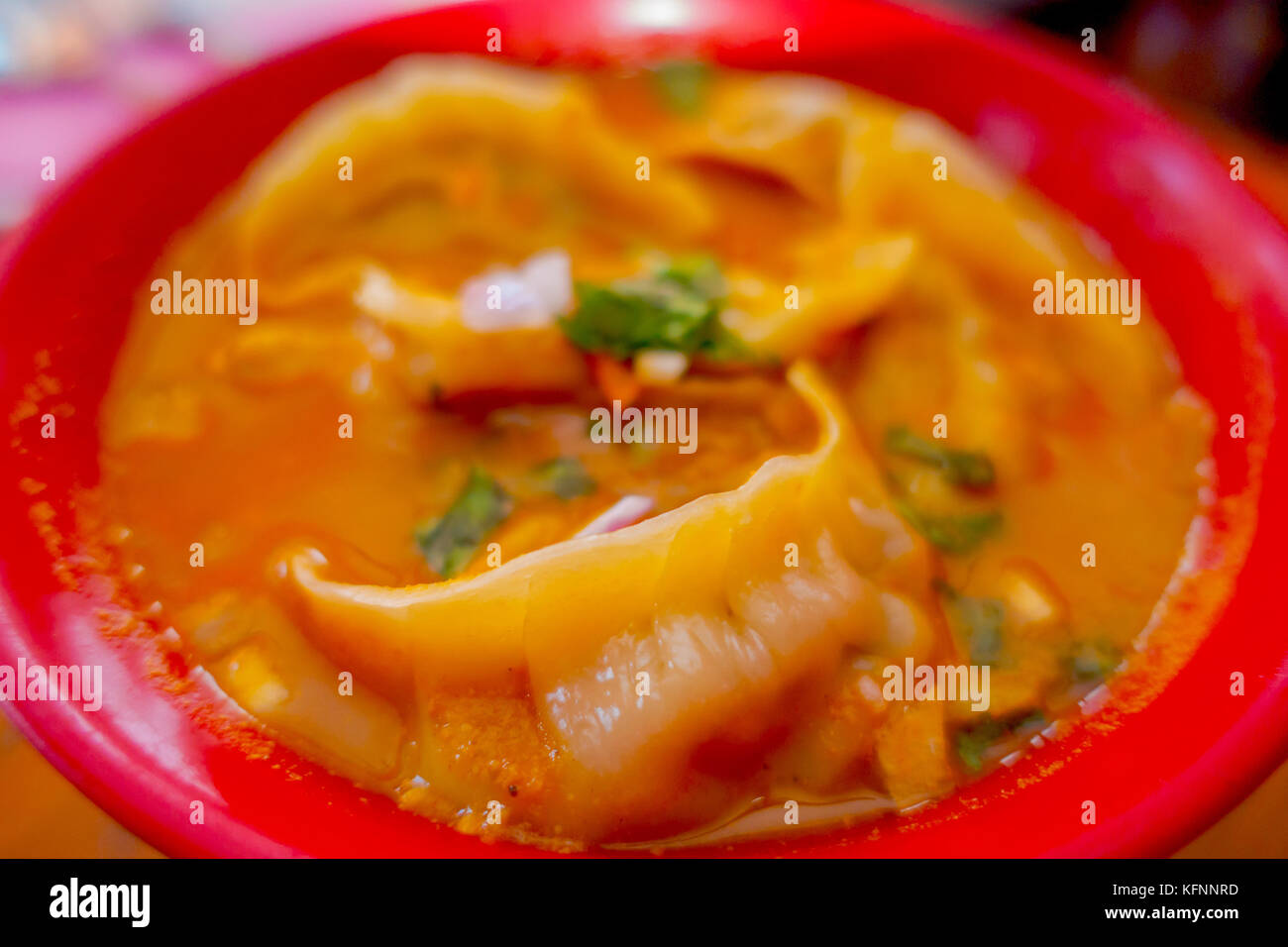 Nahaufnahme der gedämpfte Suppe von Momo in einer roten Schüssel serviert. Ein beliebtes Nepalesisches Essen, die auch im Val di Chiana, Bhutan, Tibet und Indien üblich ist Stockfoto