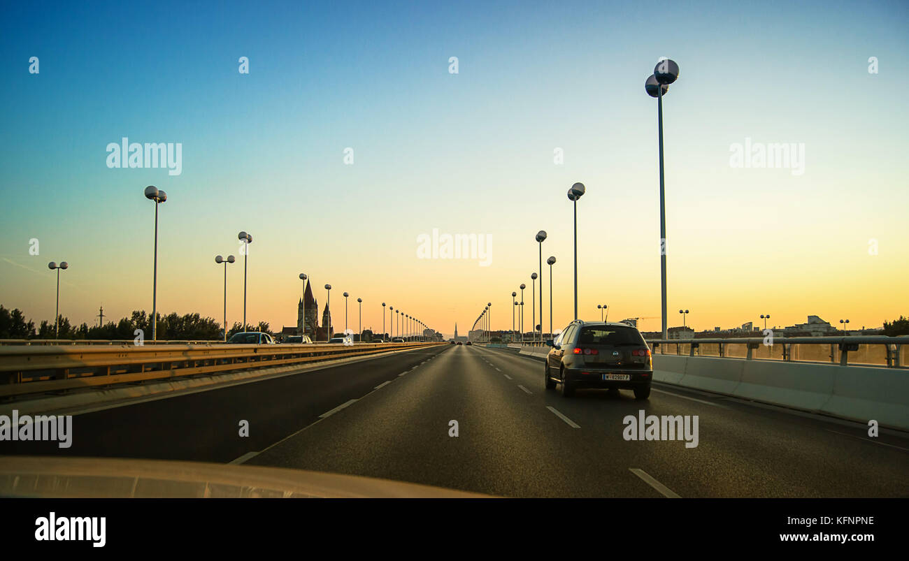 Fahrt über die Reichsbrücke bei Sonnenuntergang, Fernsicht auf die Innenstadt und die St. Stephan Kirche Wien Österreich 30.08.2015 Stockfoto