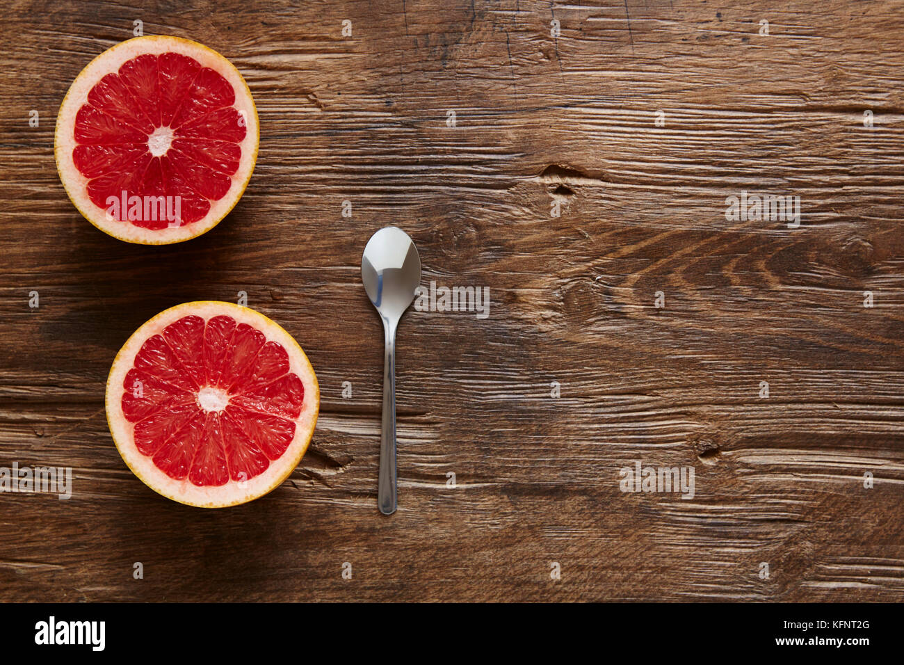 Bio Grapefruit und Löffel bereit zu essen, halbiert Stockfoto