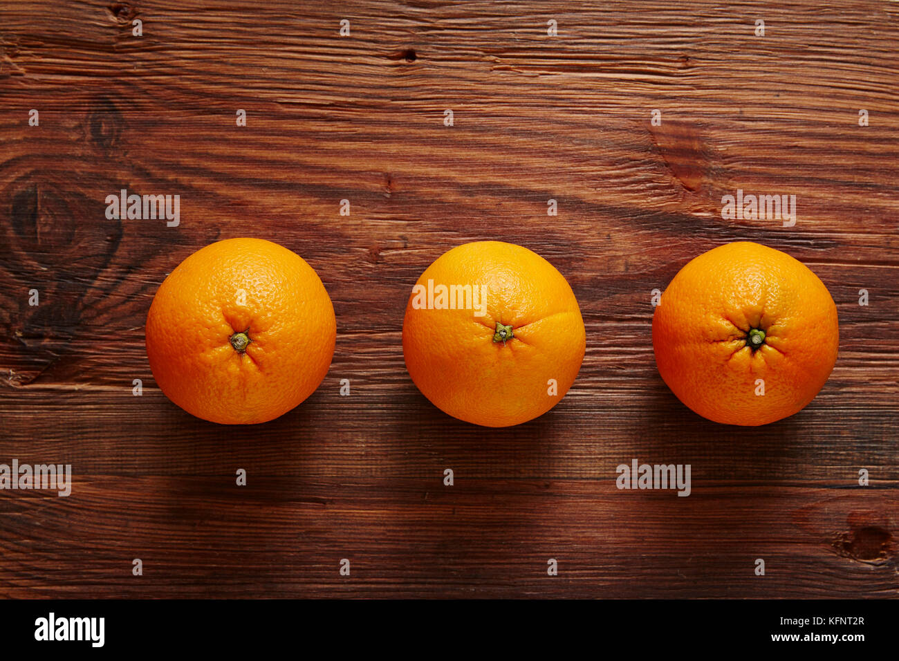 Drei organische Orangen in einer Reihe von drei Stockfoto