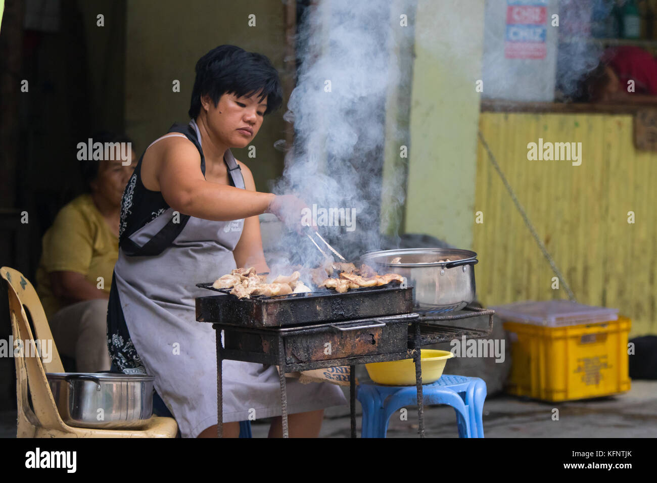 Eine philippinische Frau, die beim jährlichen Imbayah Festival in Banaue, Philippinen, Straßenessen kocht Stockfoto