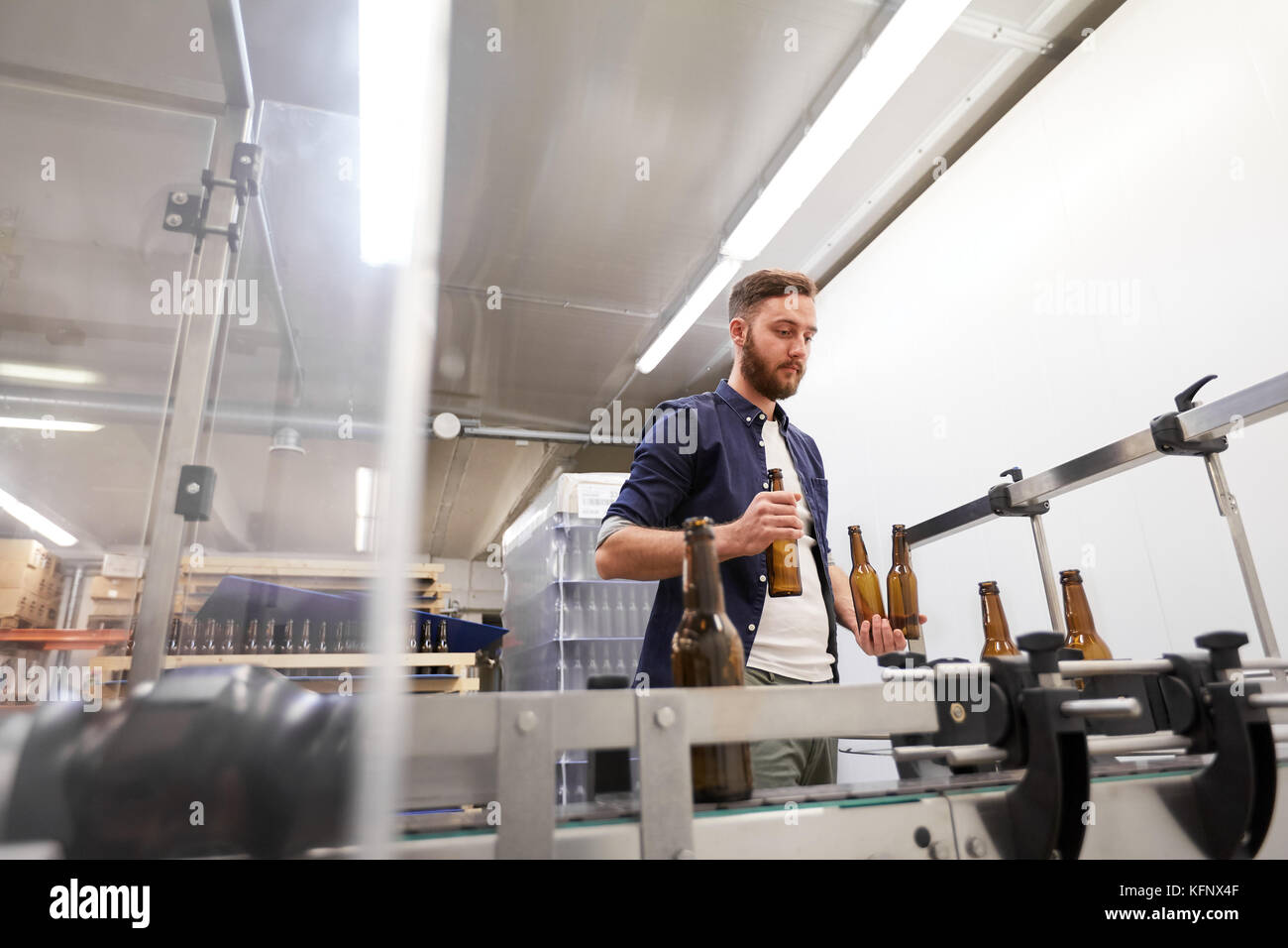 Männer mit Flaschen auf förderanlage an Handwerk Bier Brauerei Stockfoto